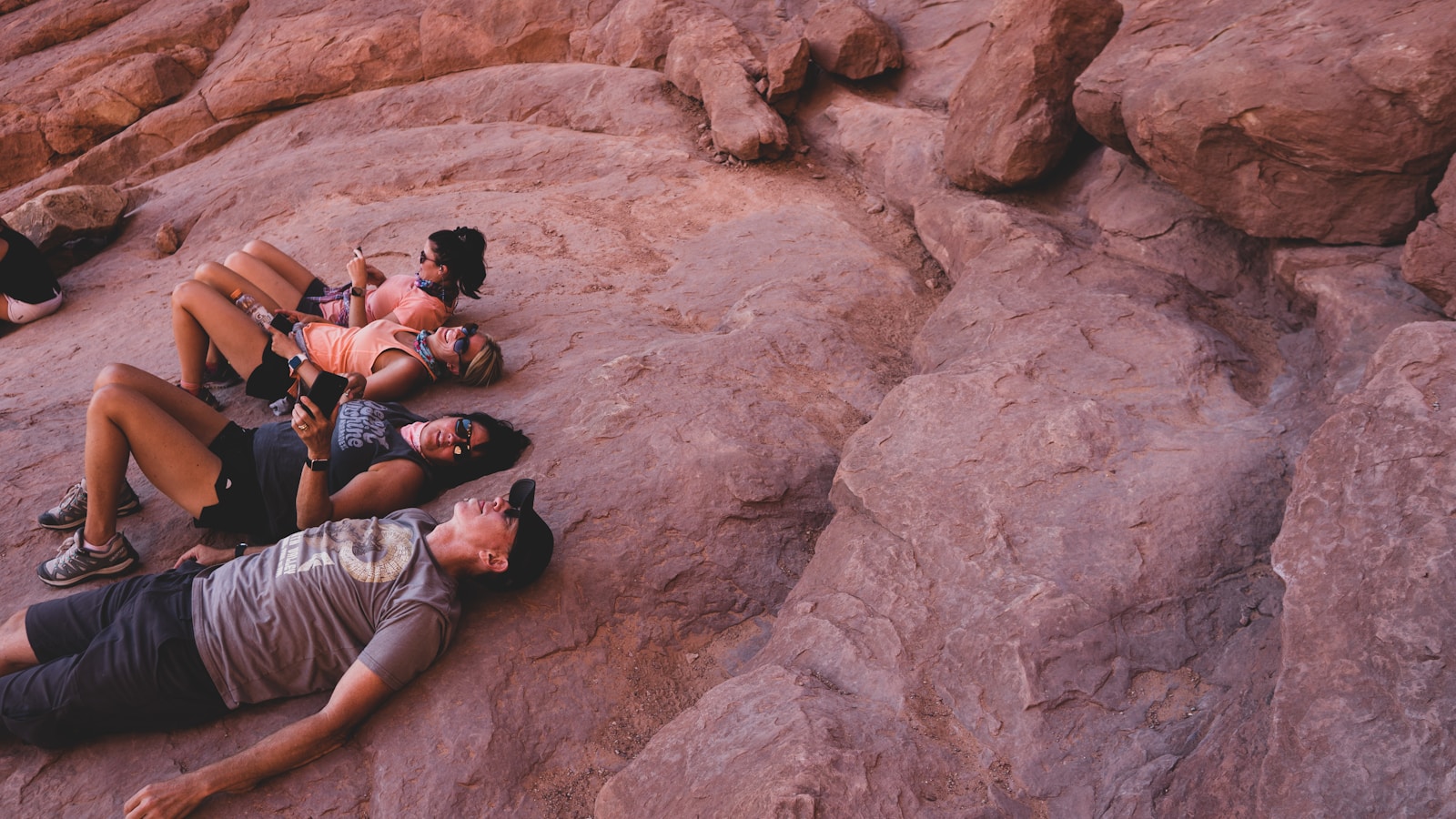 man in gray t-shirt lying on brown rock