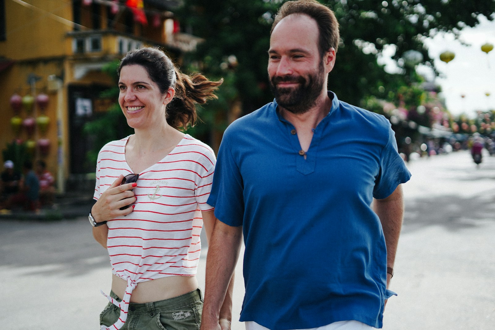 A couple walking hand in hand down a street