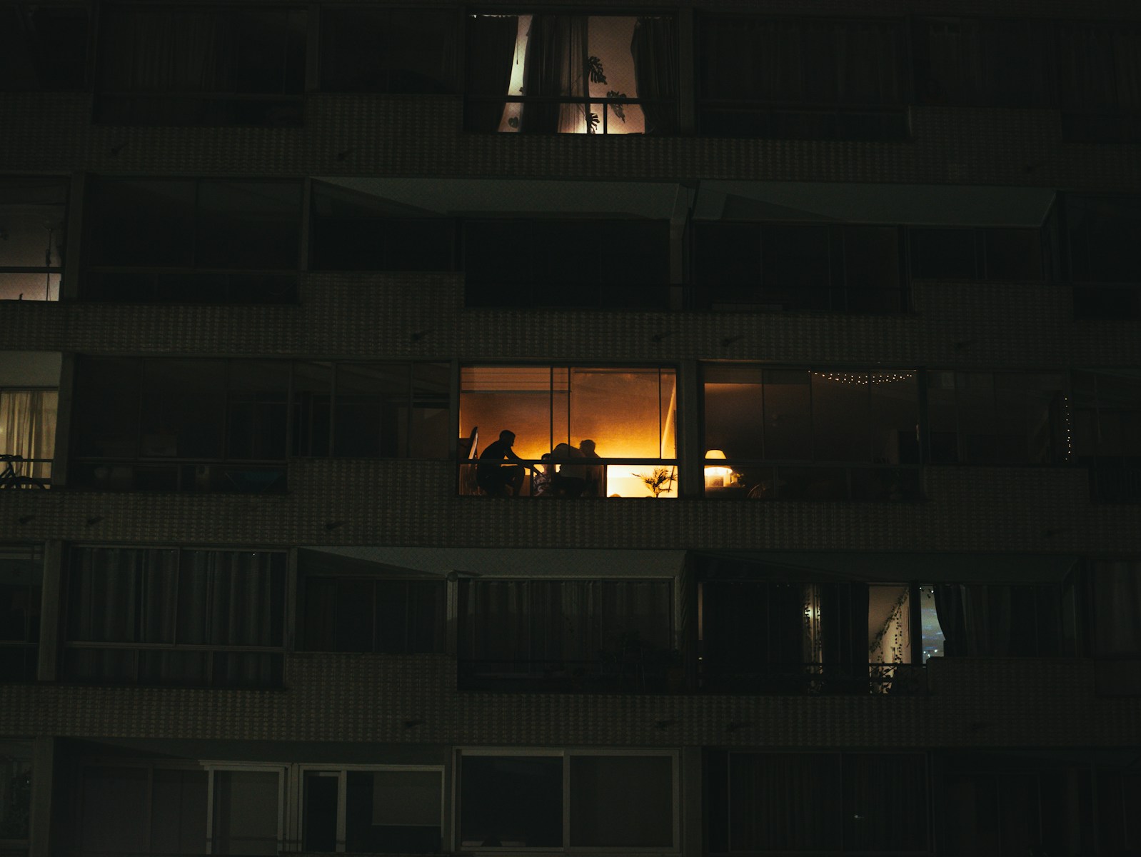 People gathered inside a brightly lit apartment at night
