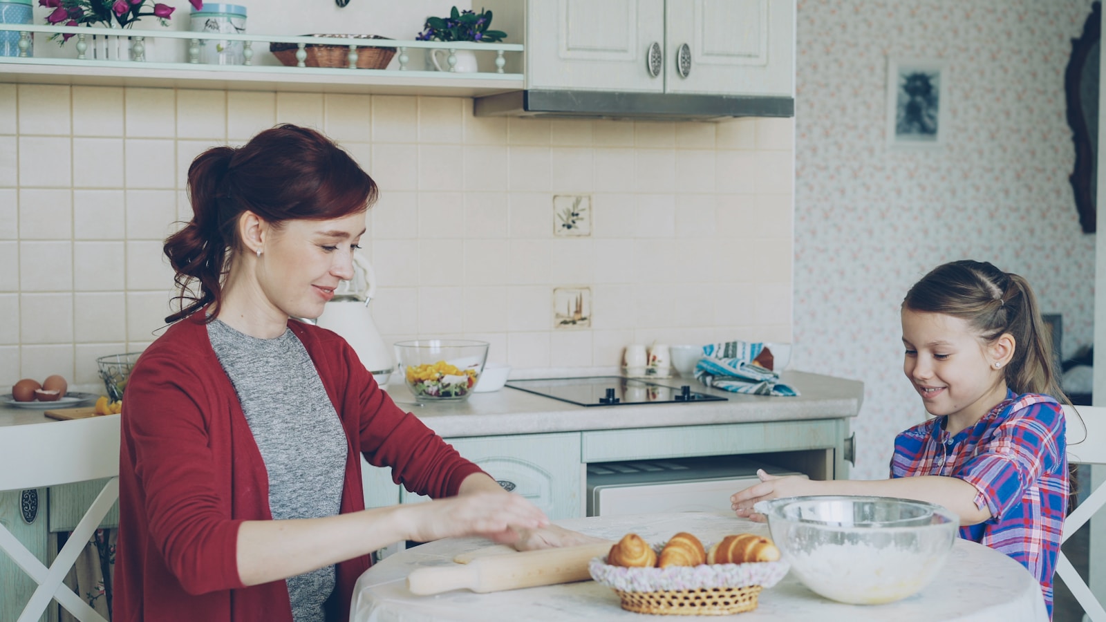 Mother and daughter bake together in the kitchen.