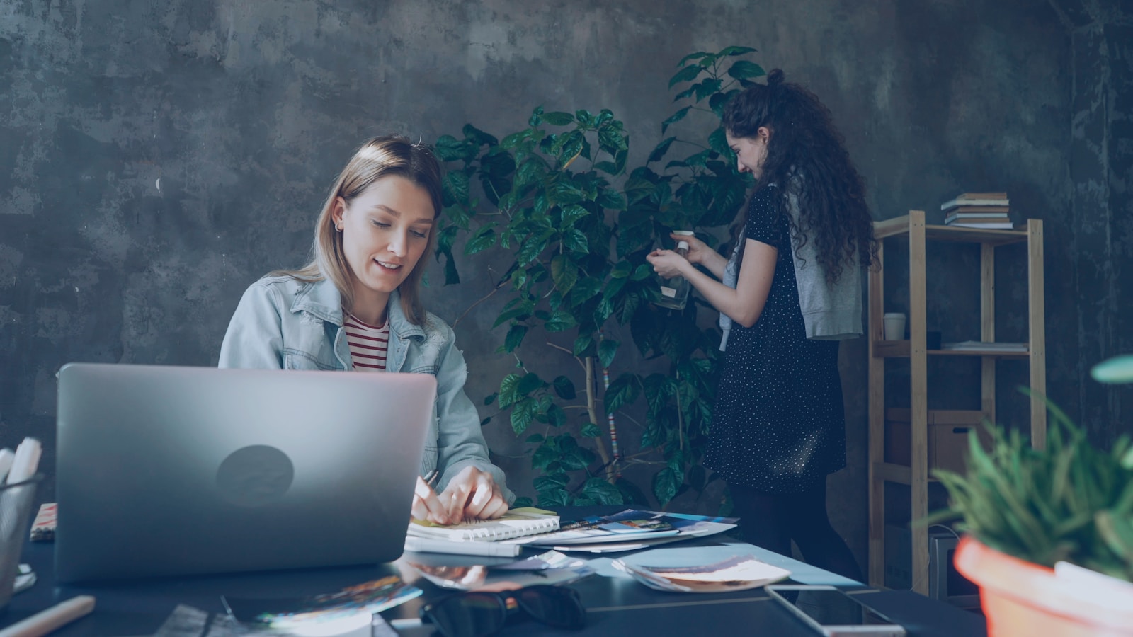 Two women work together in a creative office.