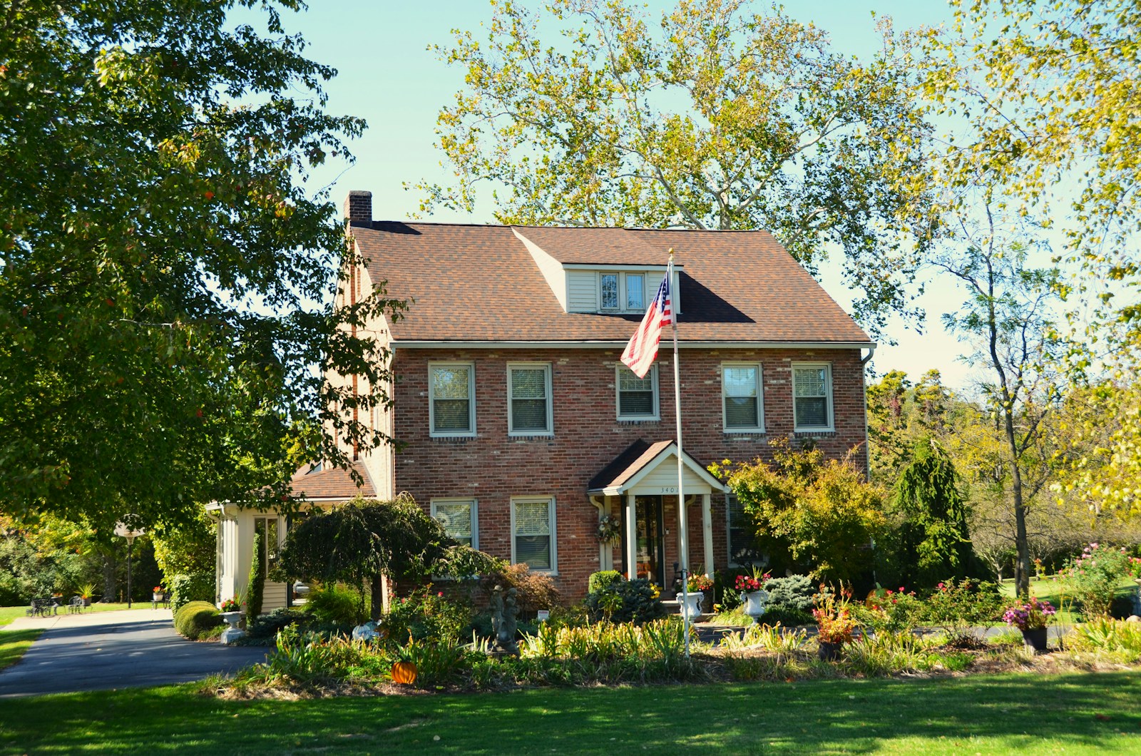 A brick house with a flag in front.