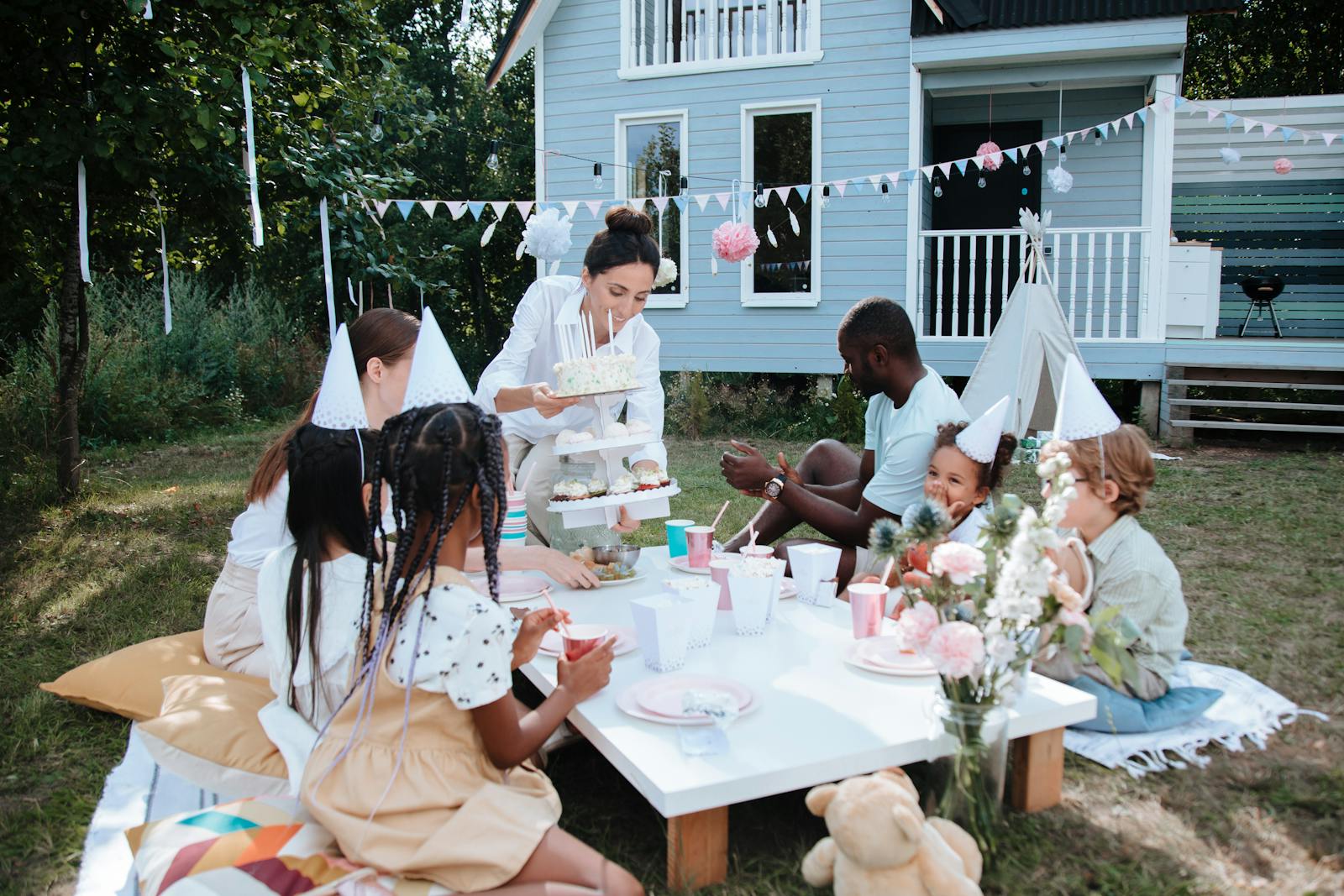 A joyful outdoor children's birthday party with cake and decorations.
