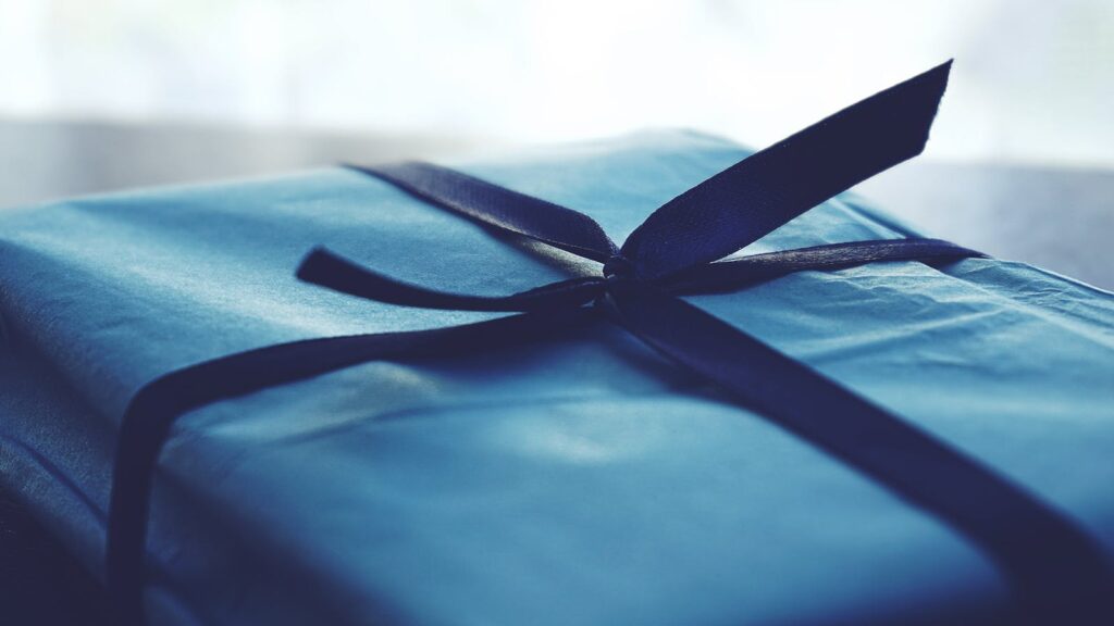A close-up of a beautifully wrapped blue gift box with a ribbon, perfect for special occasions.