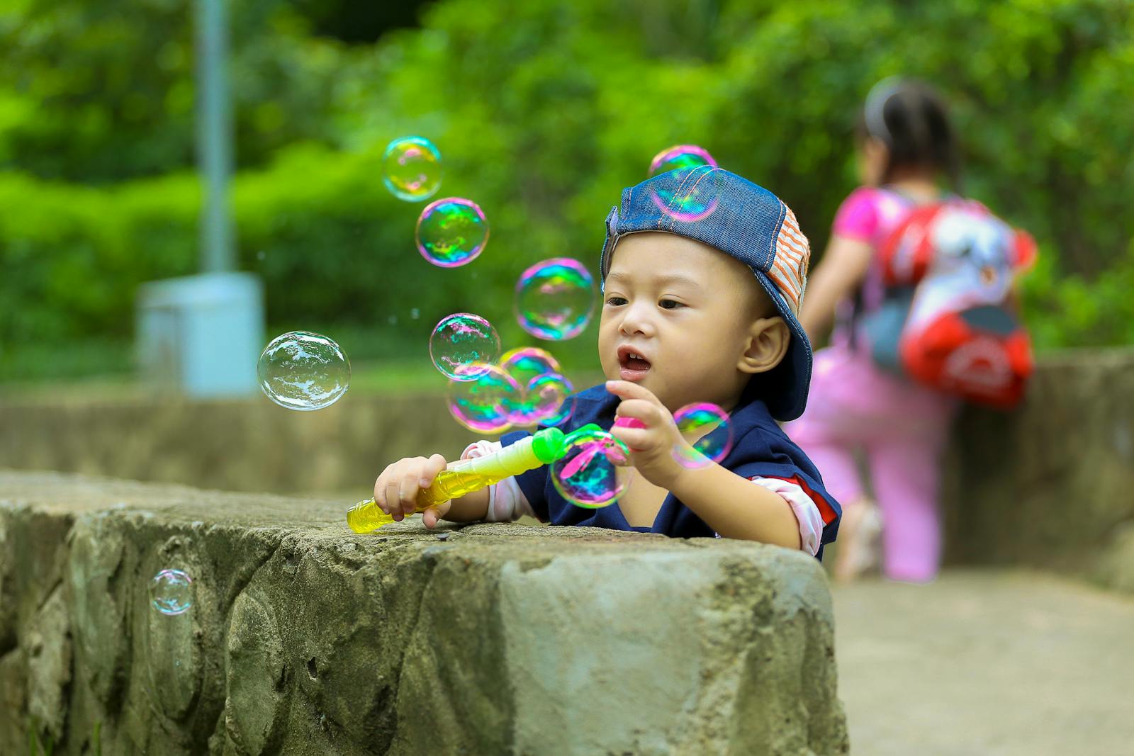 A joyful young boy playing with bubbles in a sunny park, capturing the essence of childhood fun.