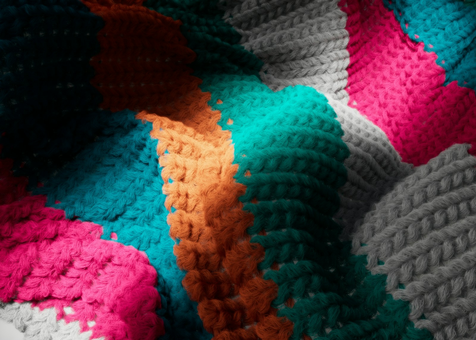 a crocheted blanket with a multicolored design