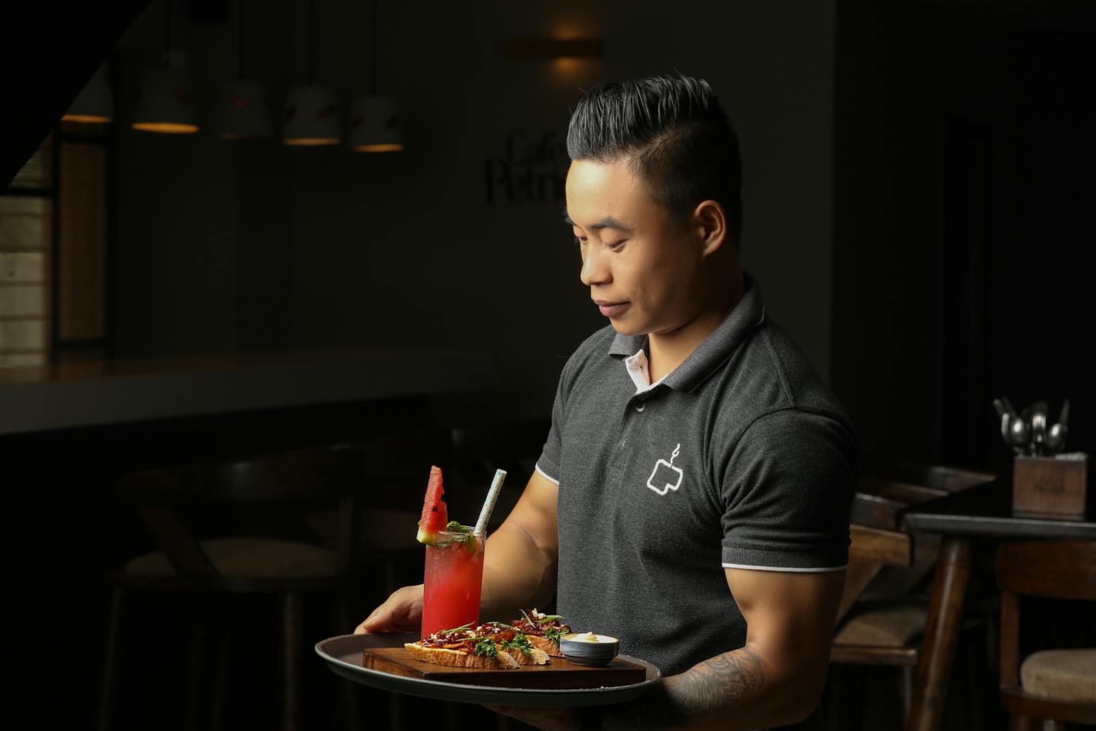A waiter serves food and a refreshing drink in a cozy restaurant setting in Bengaluru, India.