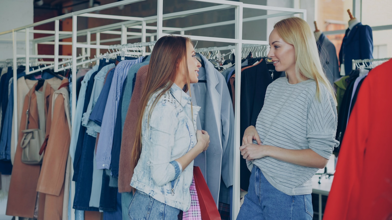 Two women are shopping for clothes in a store.