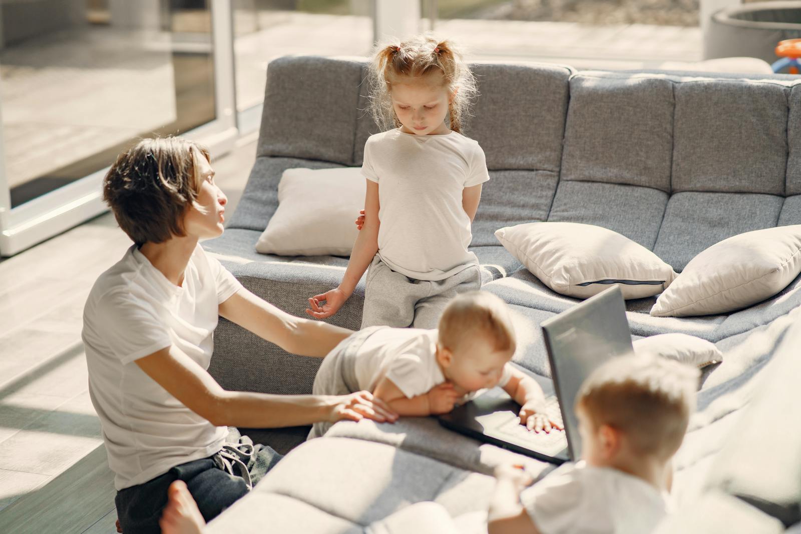 Mom and kids enjoying quality time in sunlit living room, highlighting family togetherness.