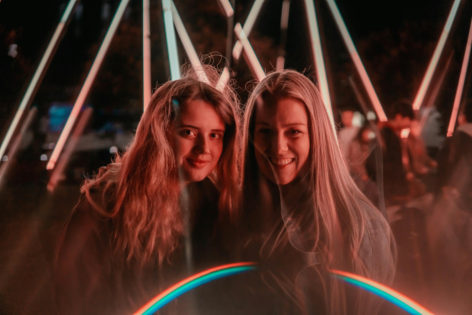 photo of 2 women across white metal poles