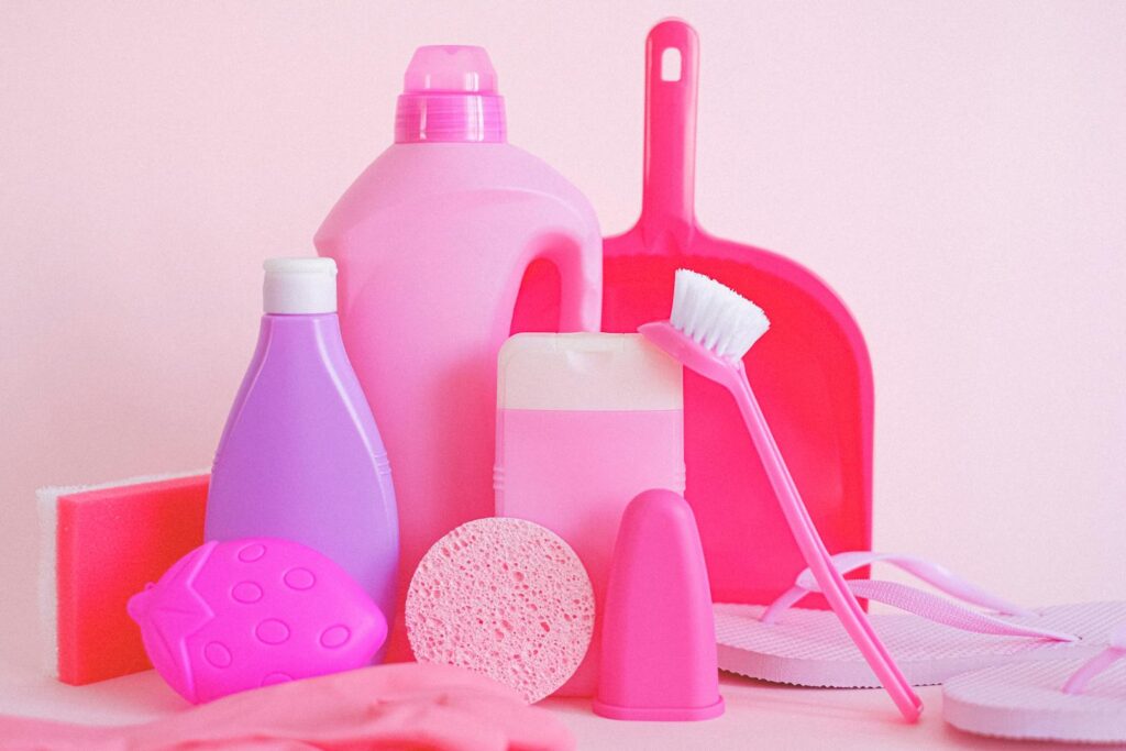A vibrant collection of cleaning products on pink background, showcasing everyday household essentials.