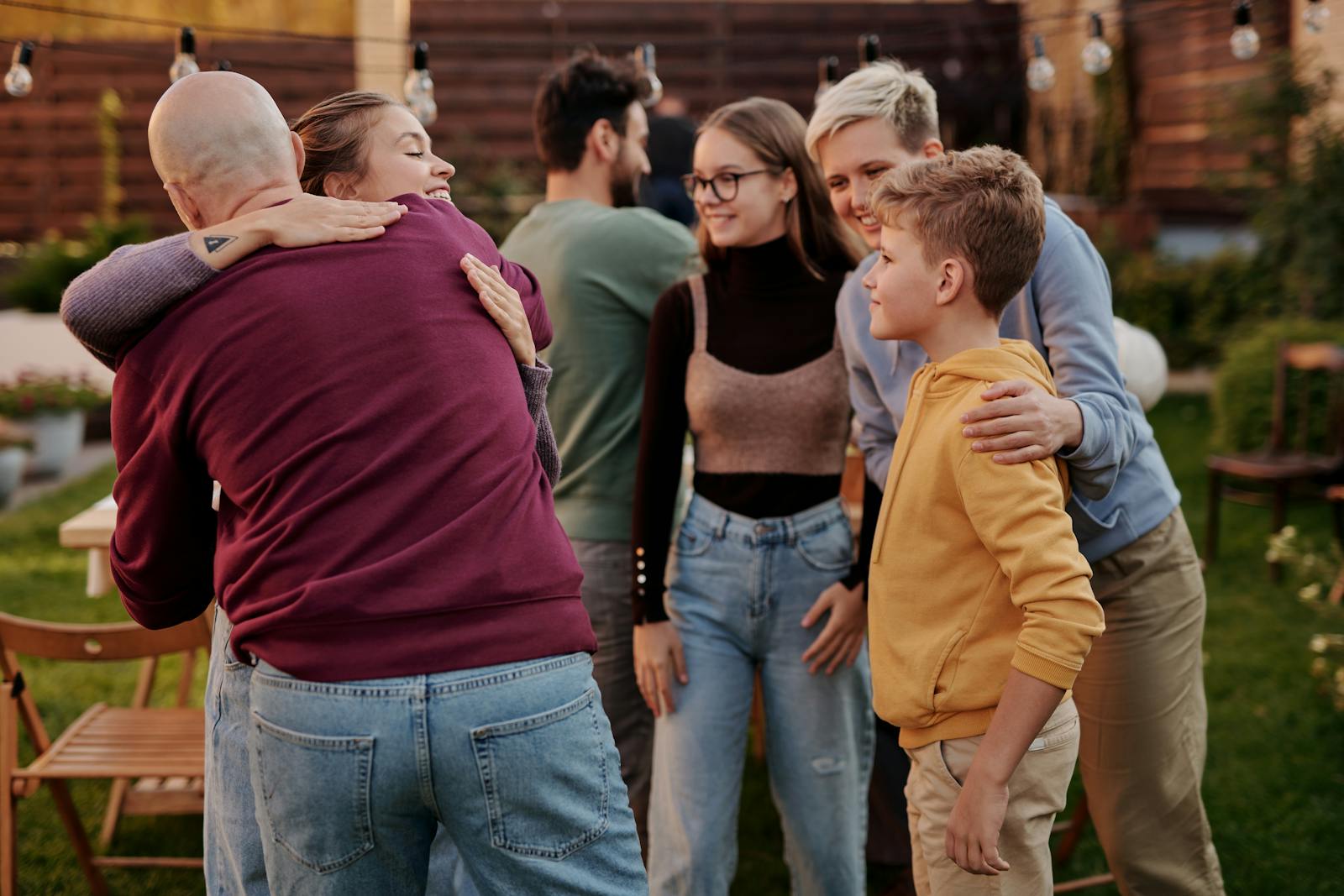 A joyful family gathering outdoors with hugs and smiles, symbolizing love and connection.