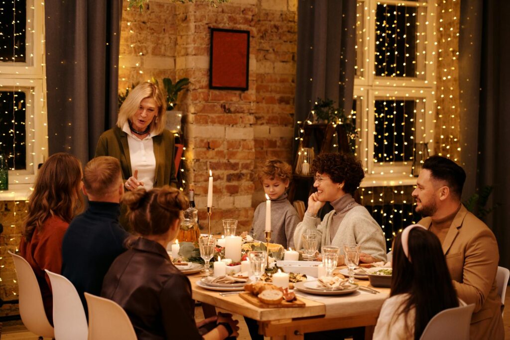 A joyful family celebrating Christmas dinner with festive decor and twinkling lights.