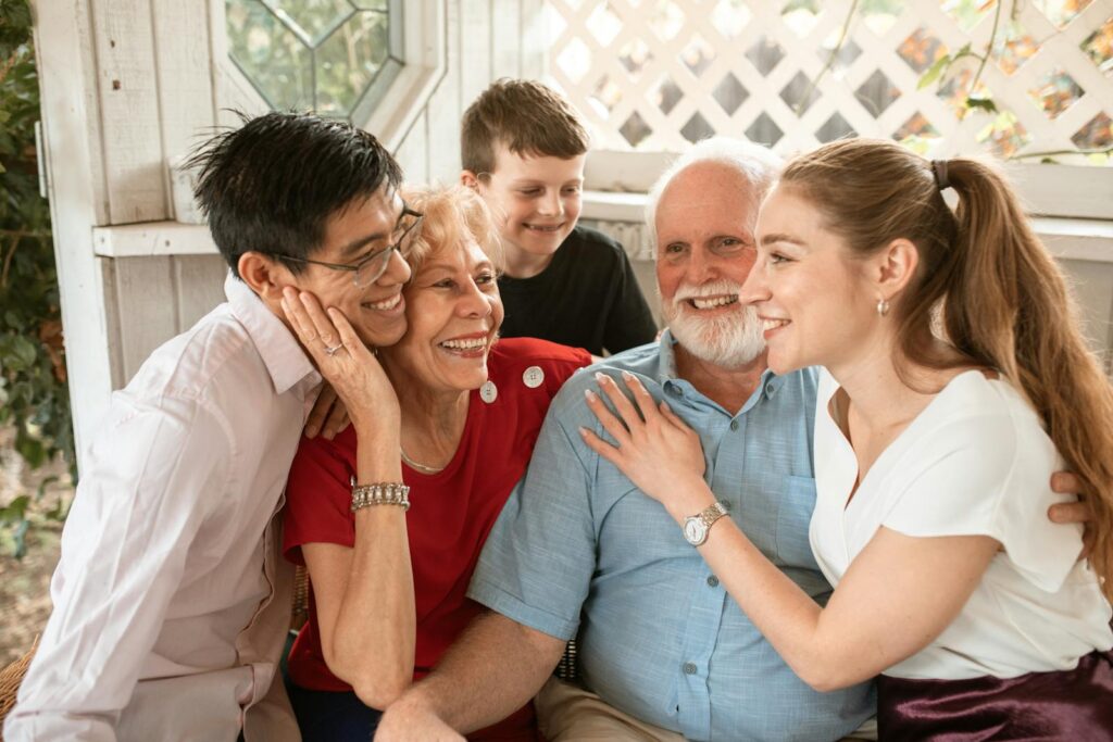 A joyful multi-generational family sharing a warm embrace indoors, depicting love and togetherness.