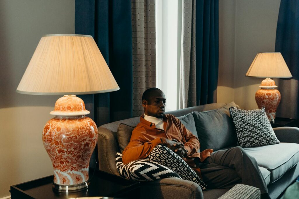 A man sits comfortably on a sofa in a stylish living room setting with elegant decor.