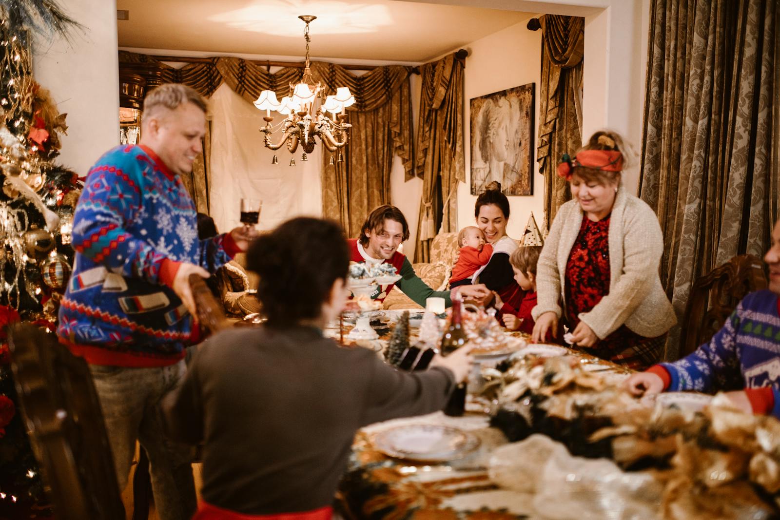 A joyful family gathering around a table decorated for Christmas, sharing food and happiness.