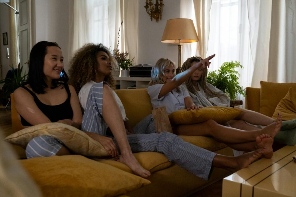 A group of women having a cozy movie night together in their living room.