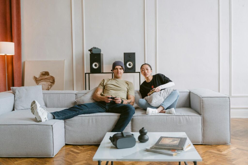 Young couple playing video games in a cozy living room, enjoying a relaxed day indoors.
