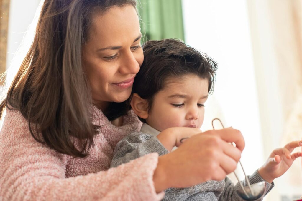 A mother and son enjoying quality time together indoors in a warm and loving environment.