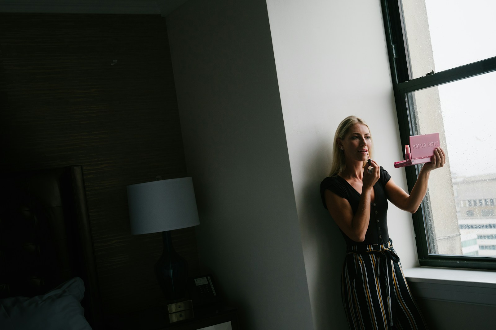 woman in black and white sleeveless dress standing near white wall