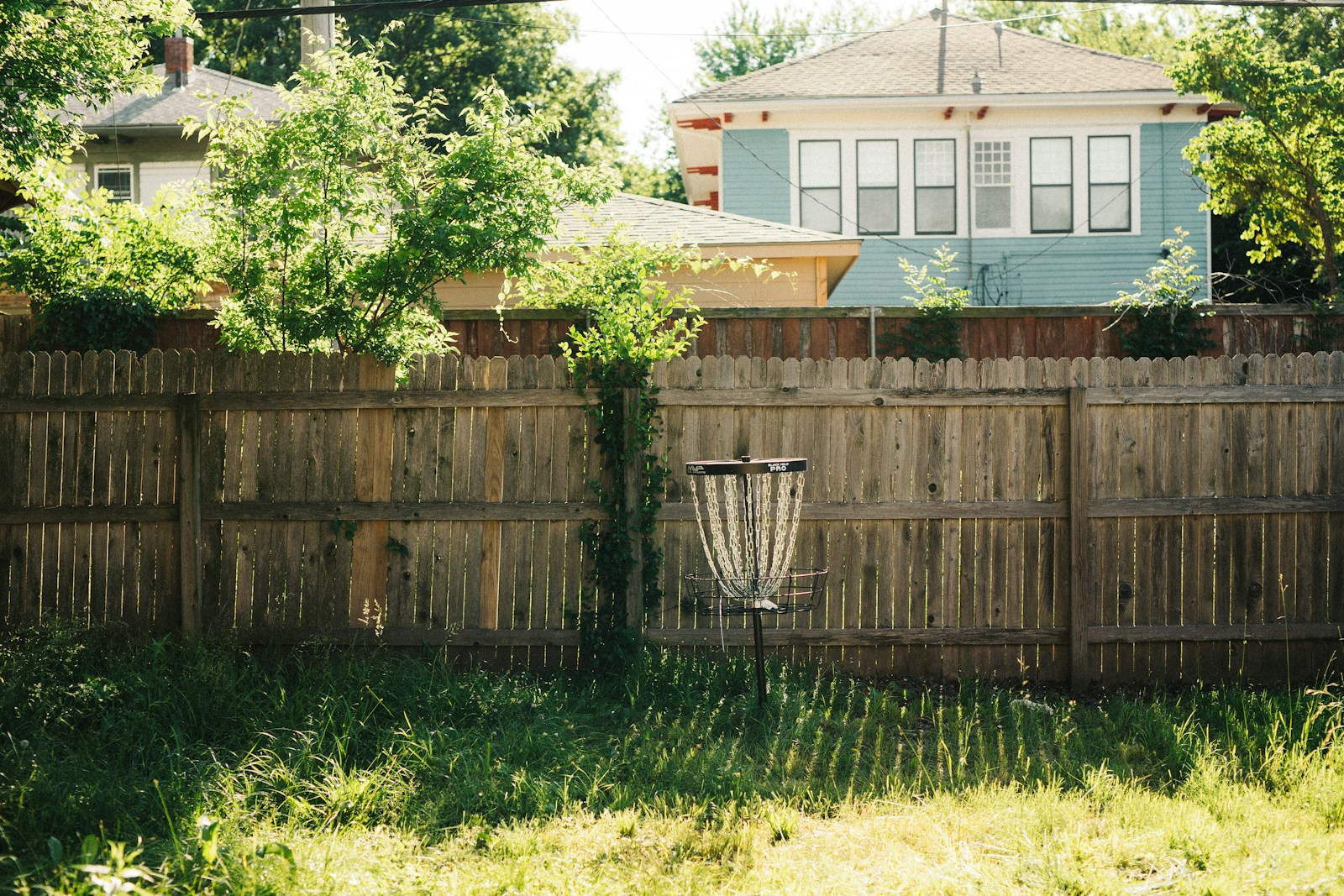 a frisbee golf goal in the back yard of a house
