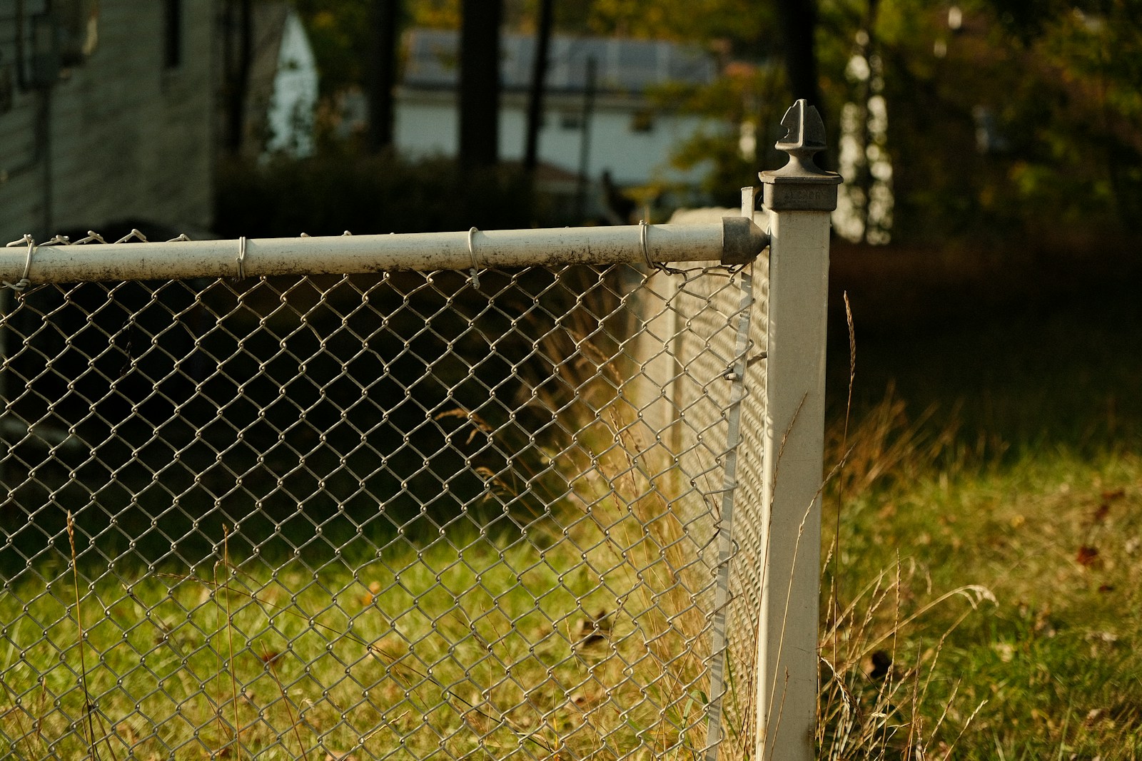 a chain link fence with a house in the background