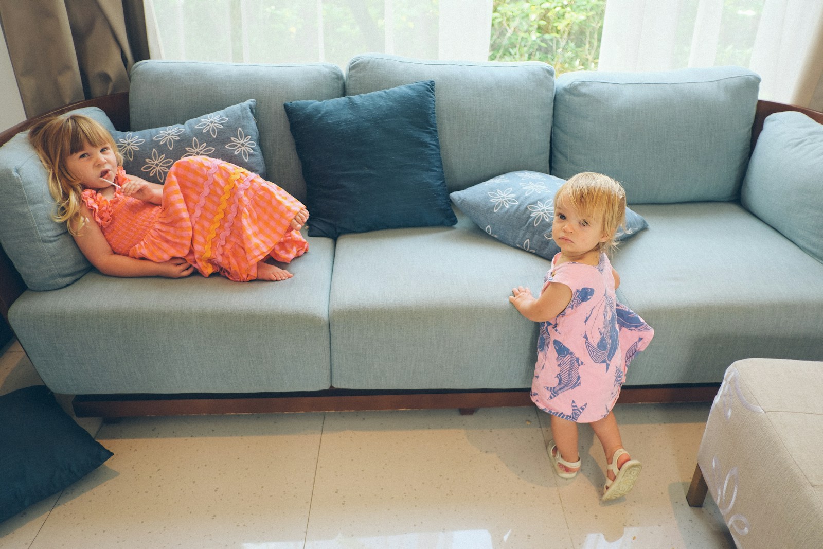 Two young girls on a light blue sofa