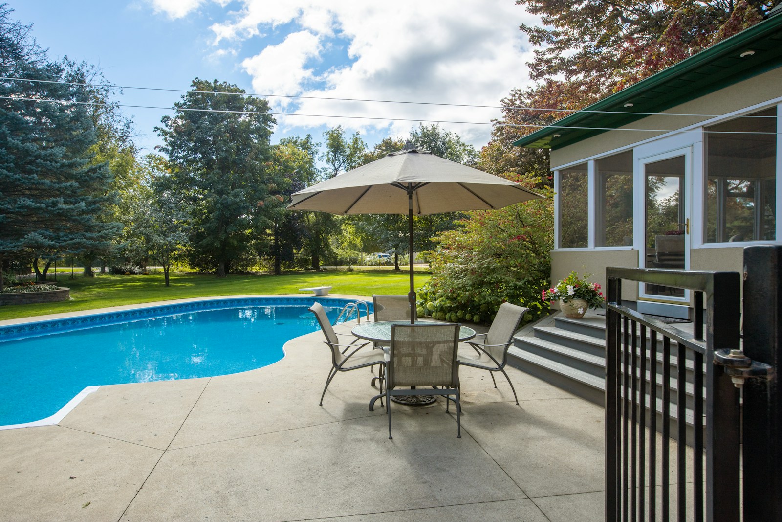 a patio with a table and chairs next to a pool