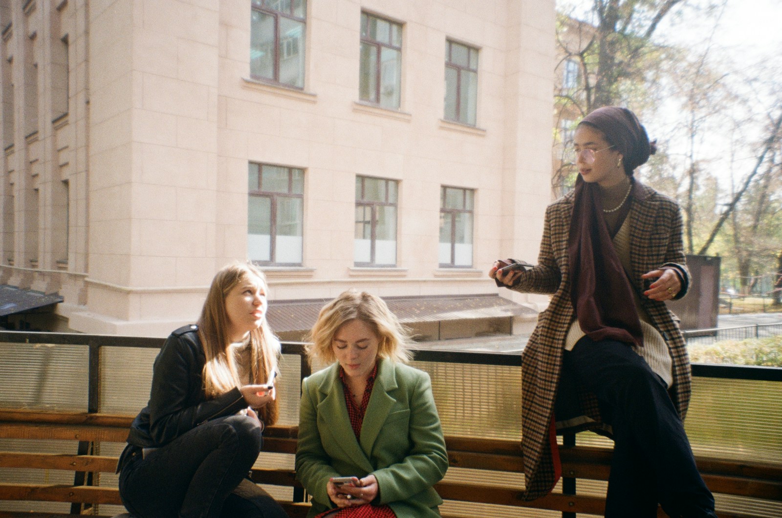 a group of women sitting on top of a wooden bench