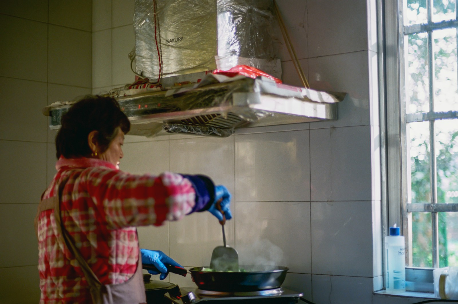 A person in a kitchen cooking food on a stove