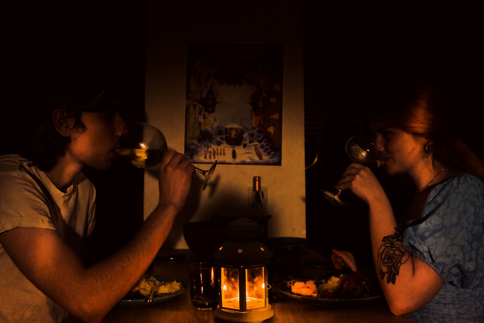 a man and a woman sitting at a table drinking wine