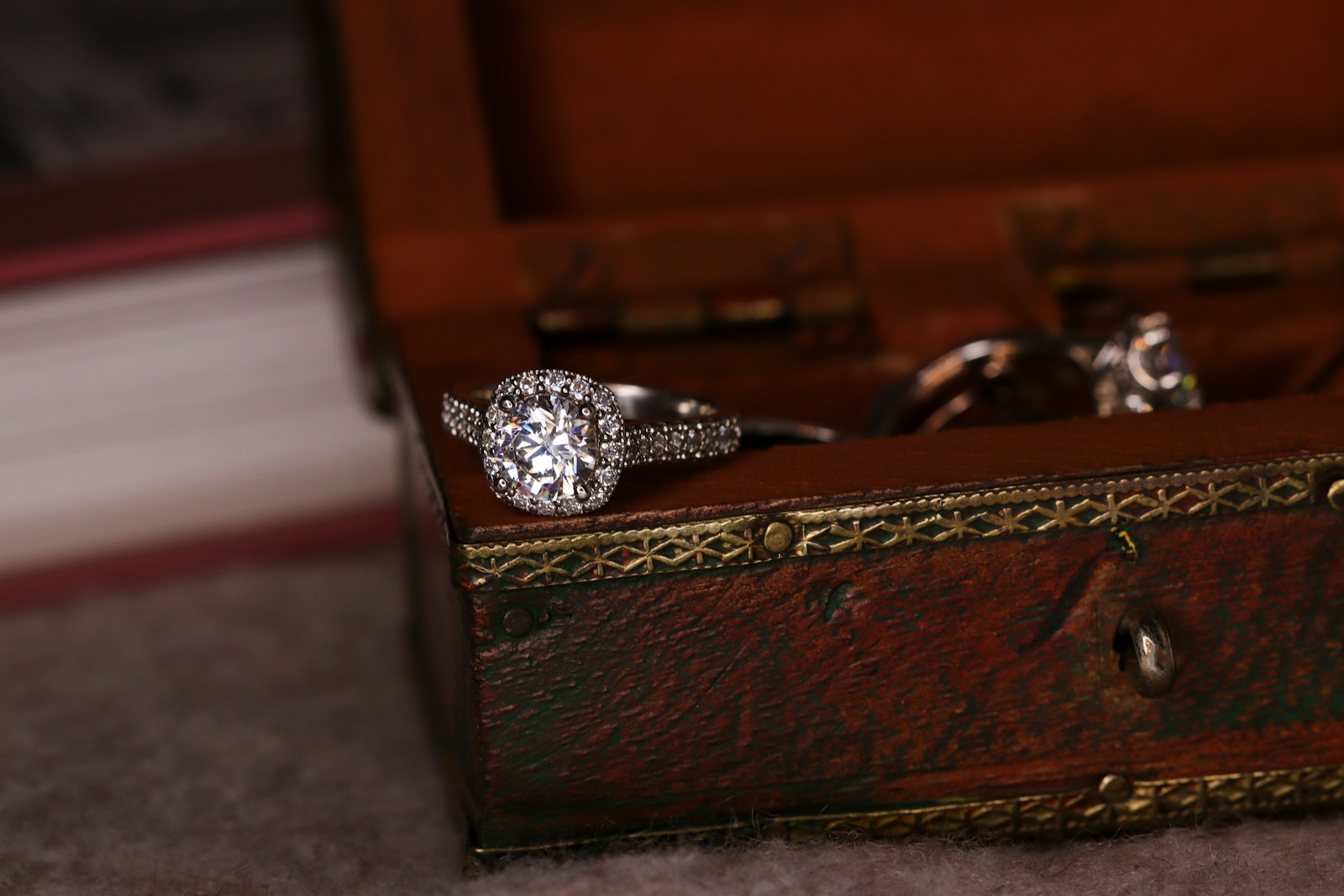 silver diamond ring on brown wooden box