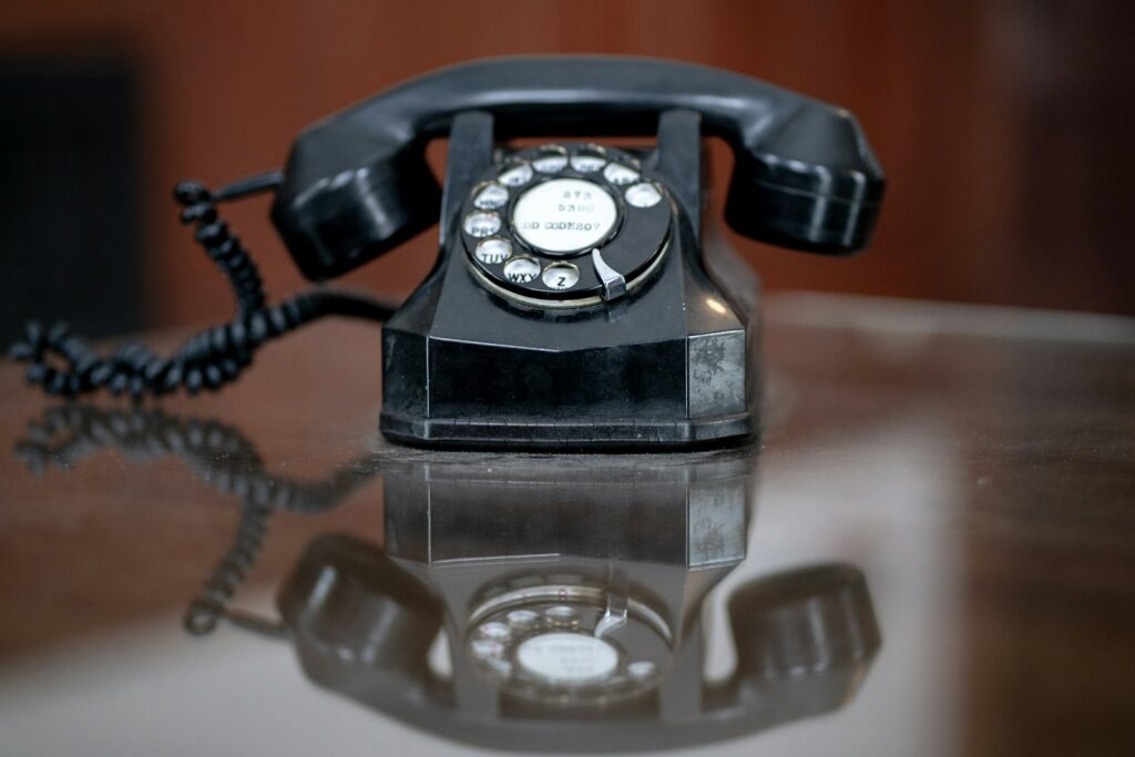black rotary phone on brown wooden table