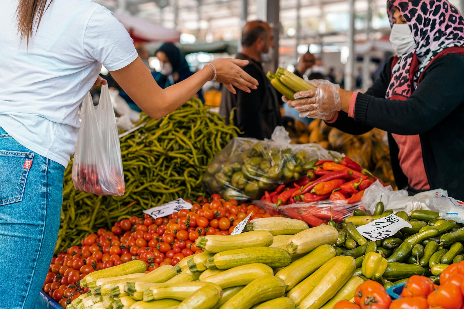 Colorful scene of a customer buying fresh vegetables from a vendor at a bustling farmers market.