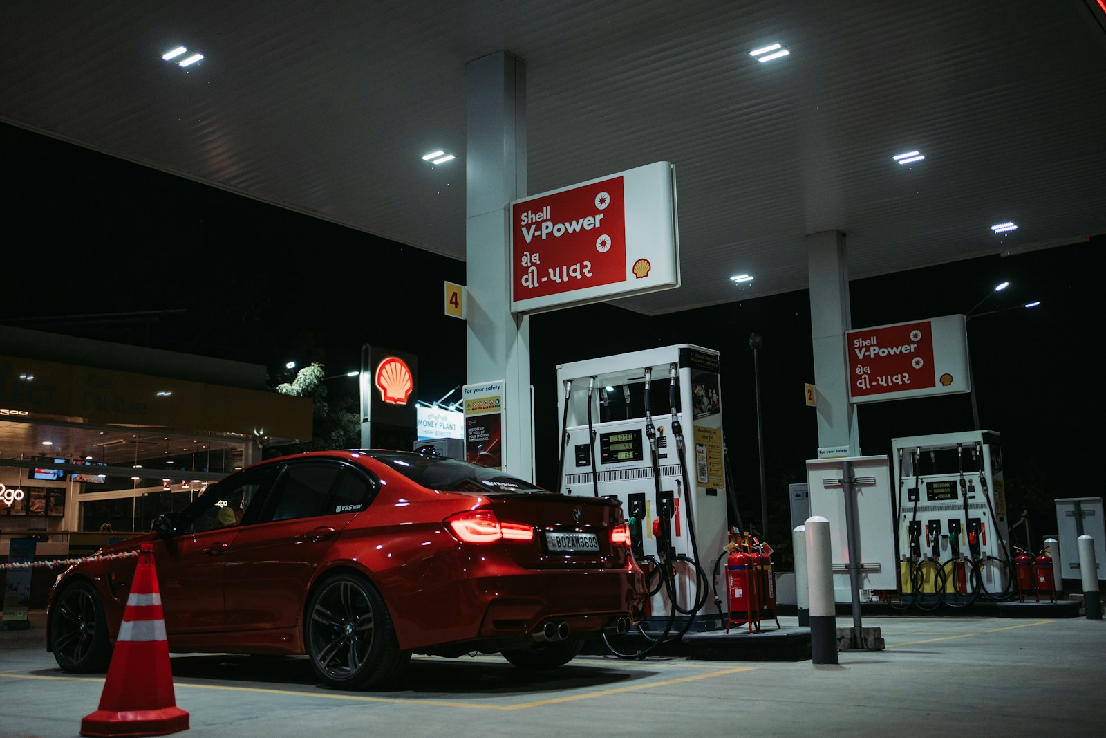 a red car is parked at a gas station