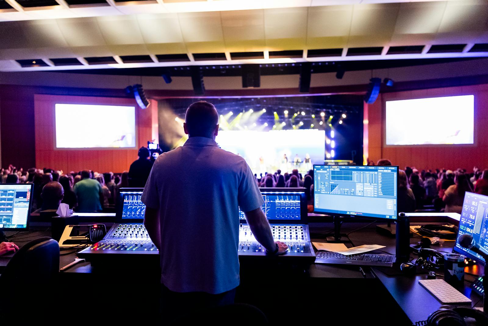Sound engineer managing control desk during a live music event in an indoor venue.