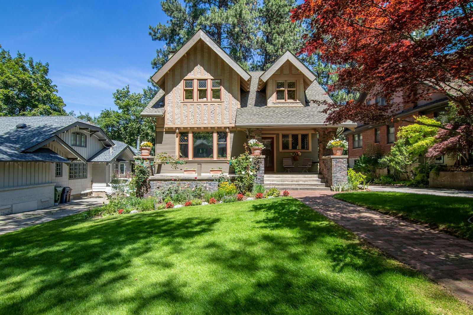 Stunning Victorian home with a manicured lawn and vibrant landscaping.