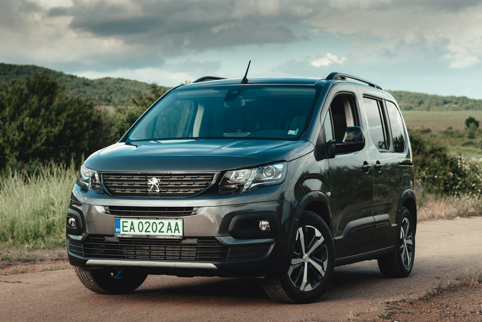 a black van is parked on a dirt road