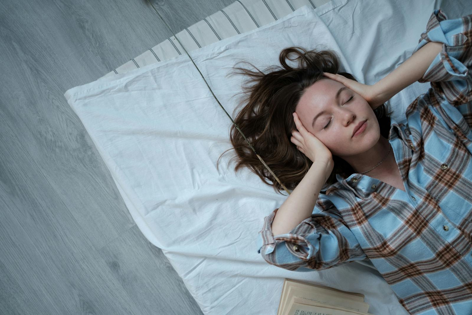 Young woman relaxing indoors on a bed, embracing tranquility and calmness.