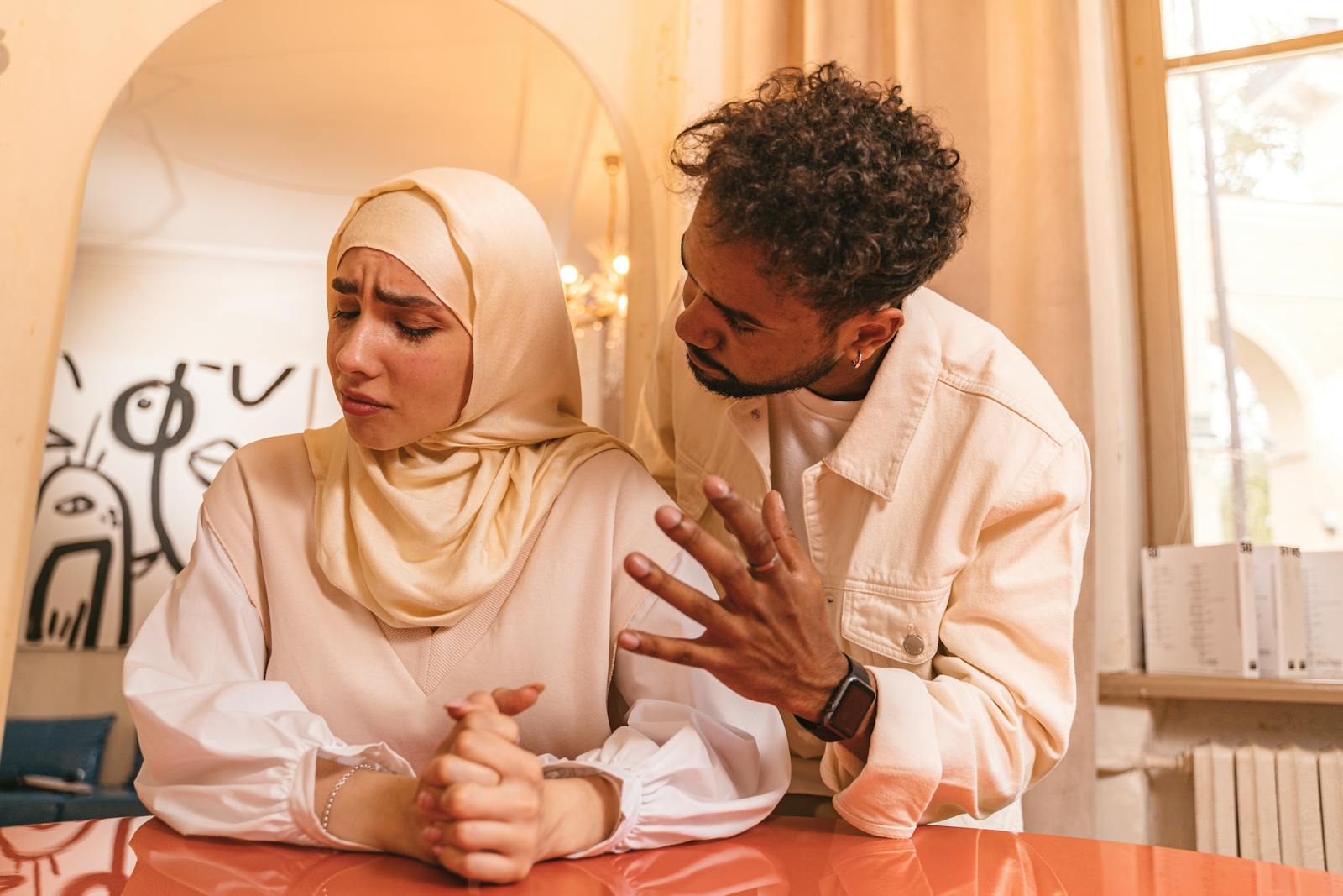 A tense moment between a man and woman indoors, highlighting relationship conflict.