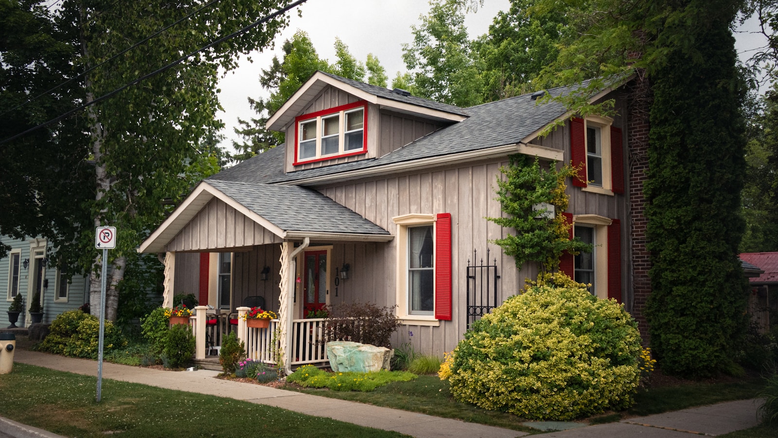 A charming two-story house with red shutters.