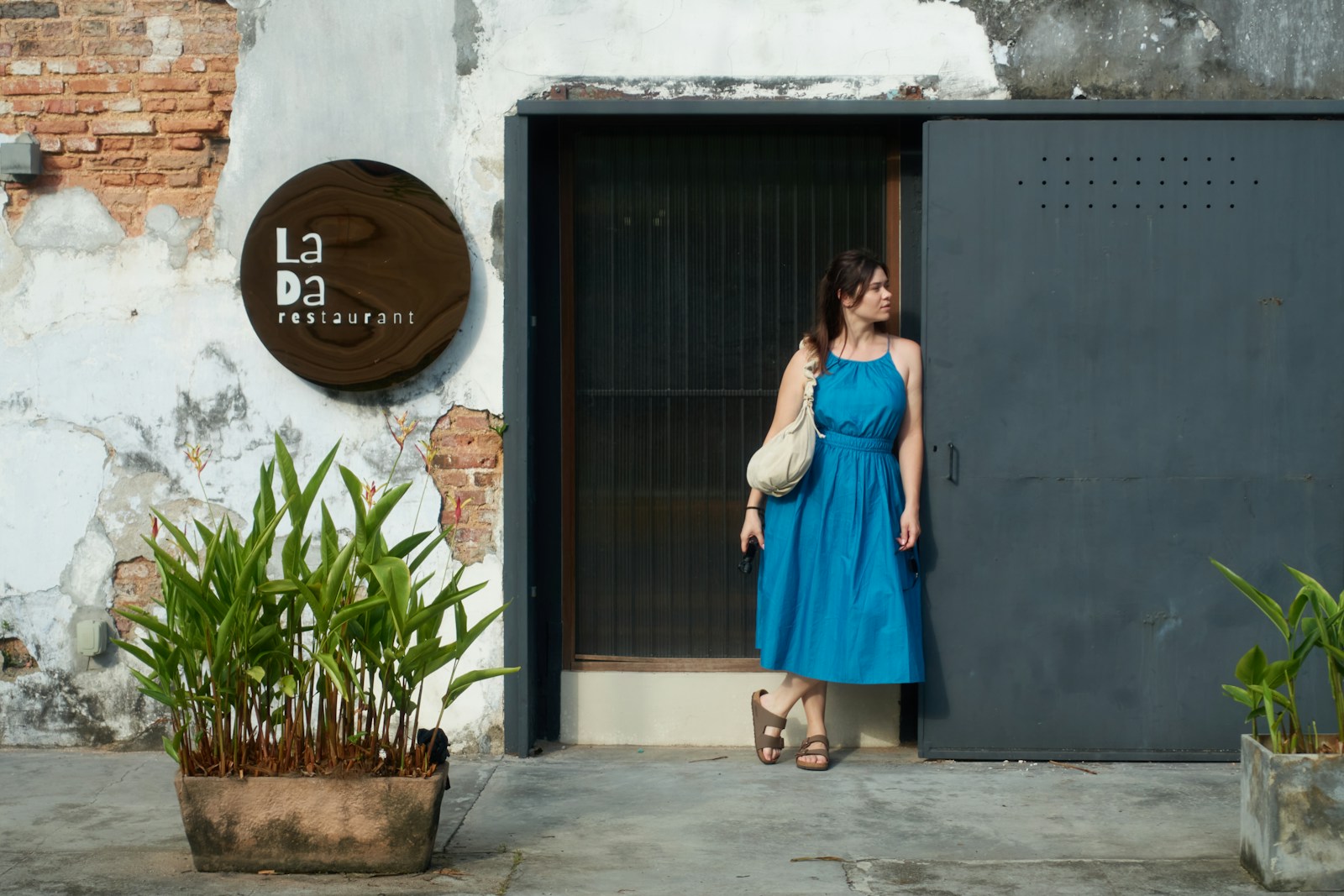 Woman in blue dress standing by a doorway