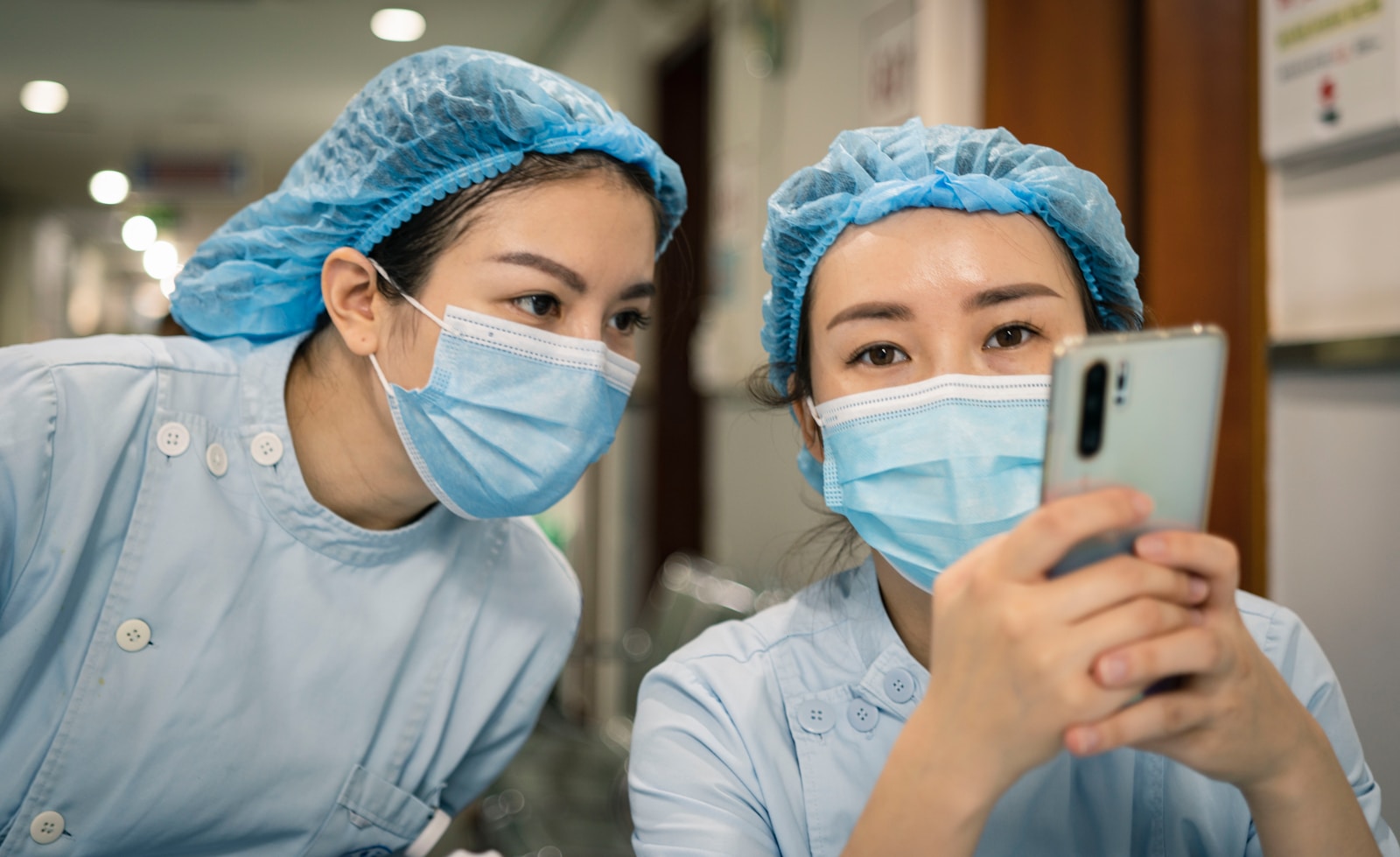 woman in white shirt wearing white mask holding iphone
