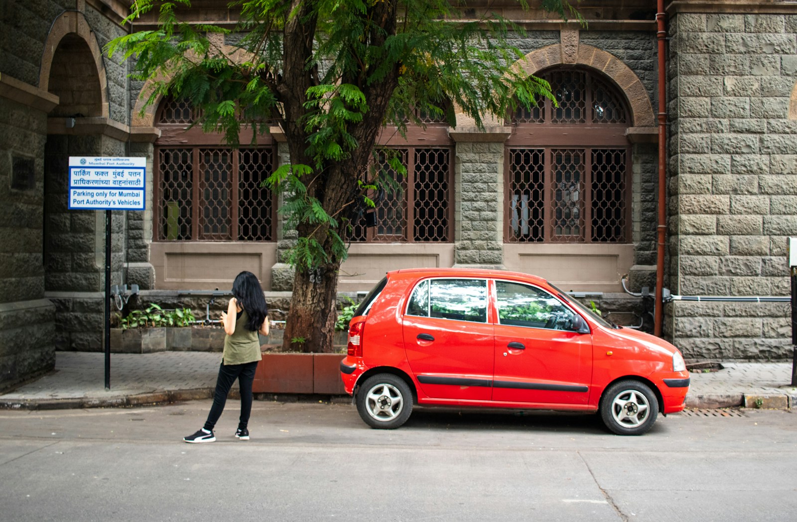 A red car is parked near a building.