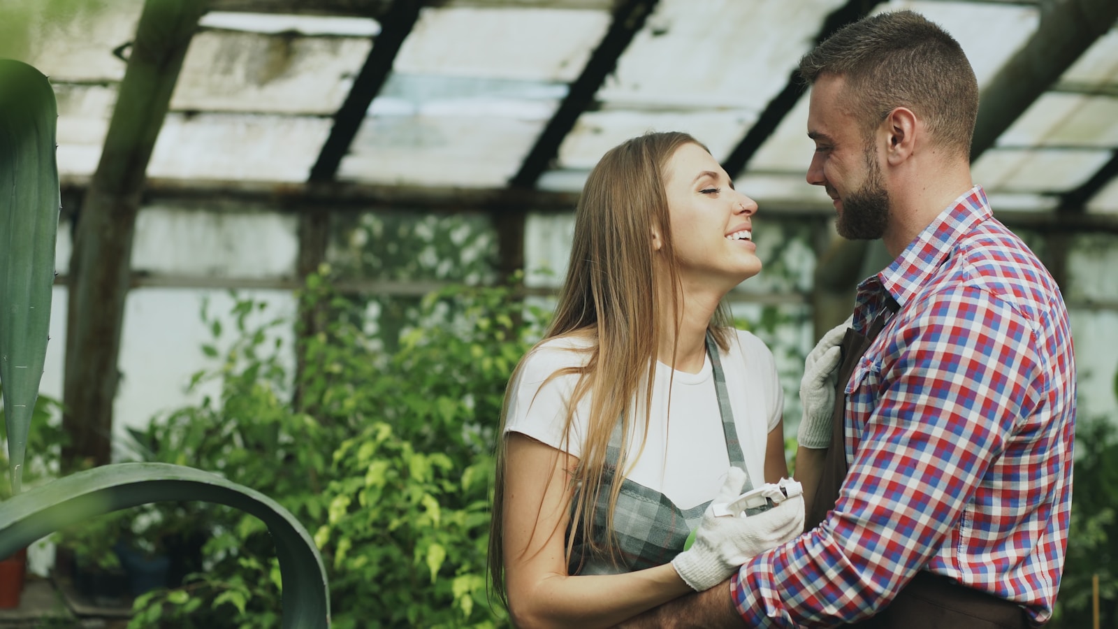 Couple embracing in a greenhouse with plants