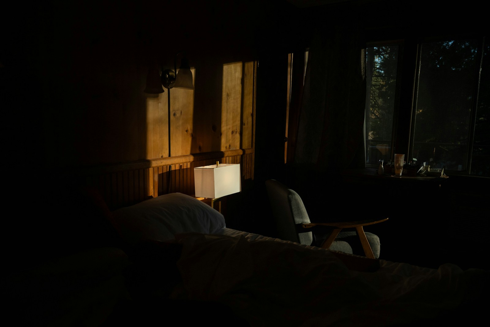 Dimly lit bedroom with sunlight through window