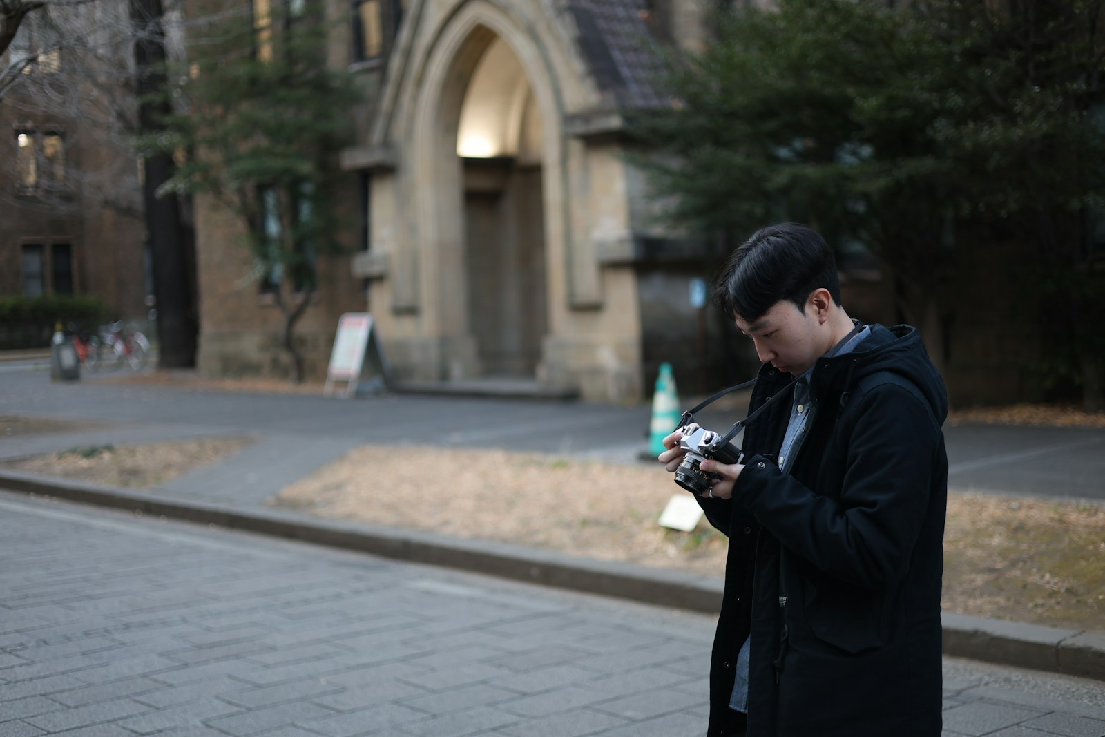 Man holding a camera in front of a building