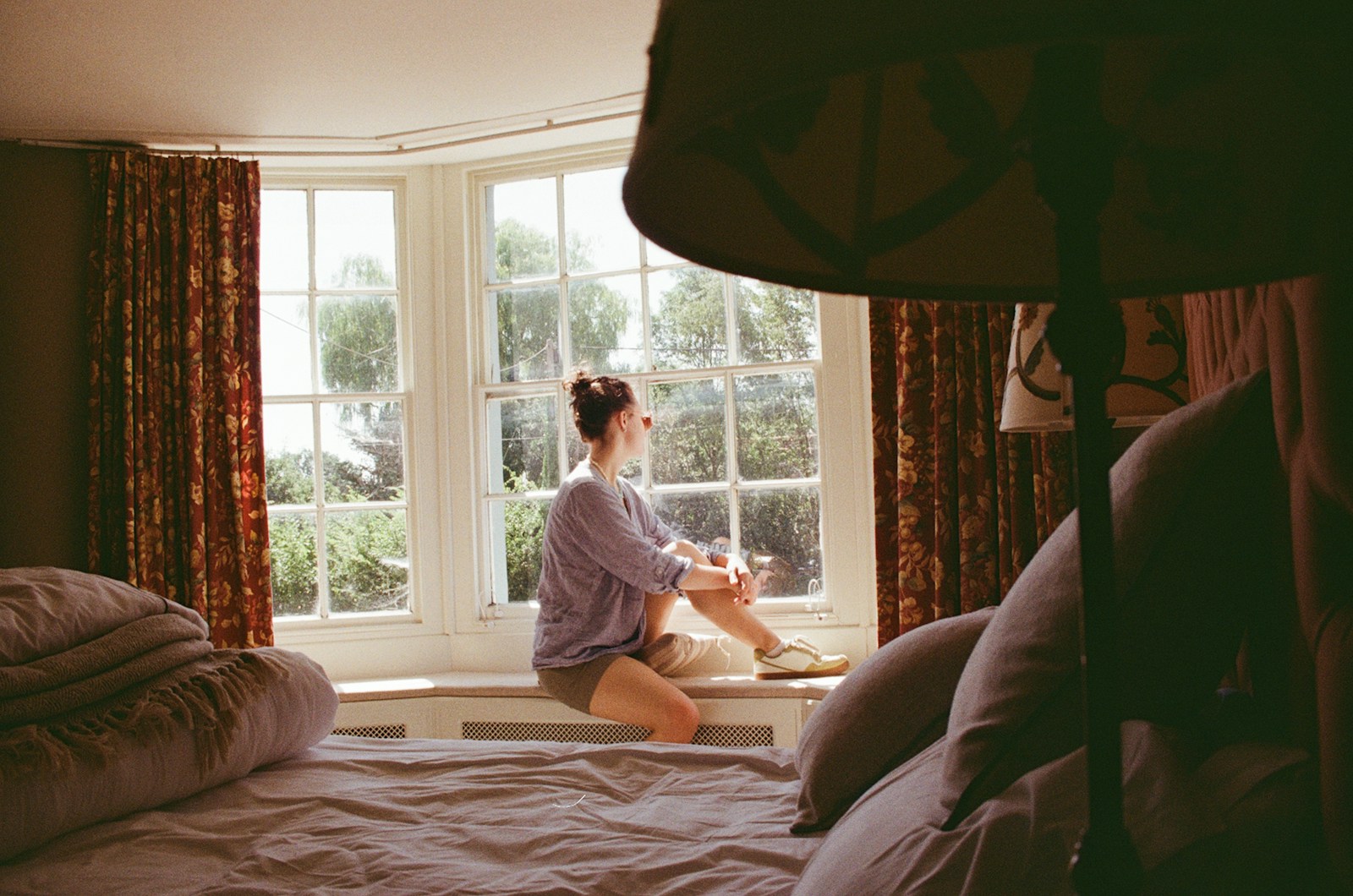 Woman looking out a large bay window