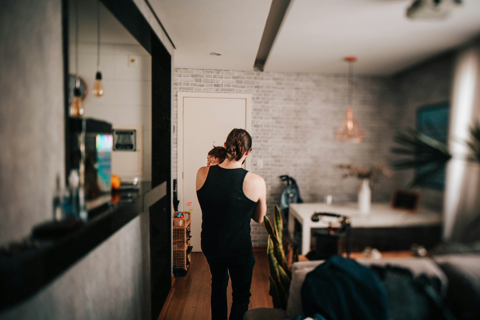 woman in black tank top and black pants standing on brown wooden floor