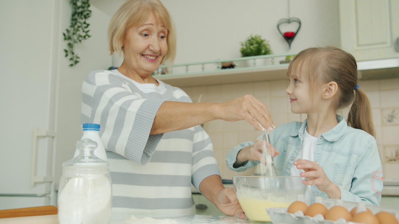 Grandmother and granddaughter baking together in kitchen